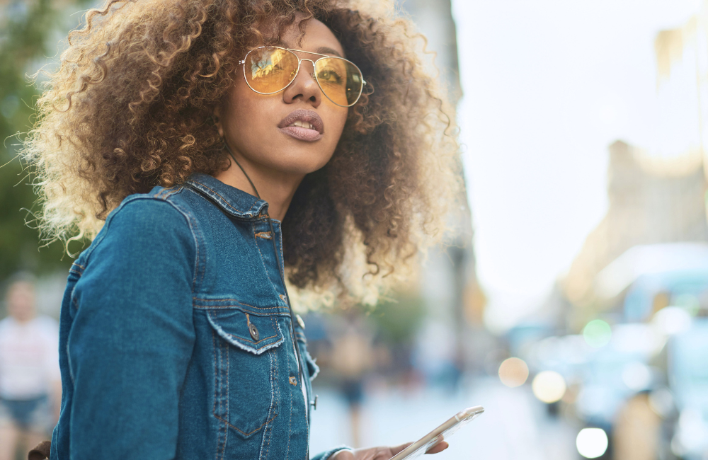 moderne vrouw met zonnebril en telefoon in de stad