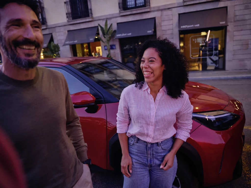 rode toyota auto met twee personen ervoor